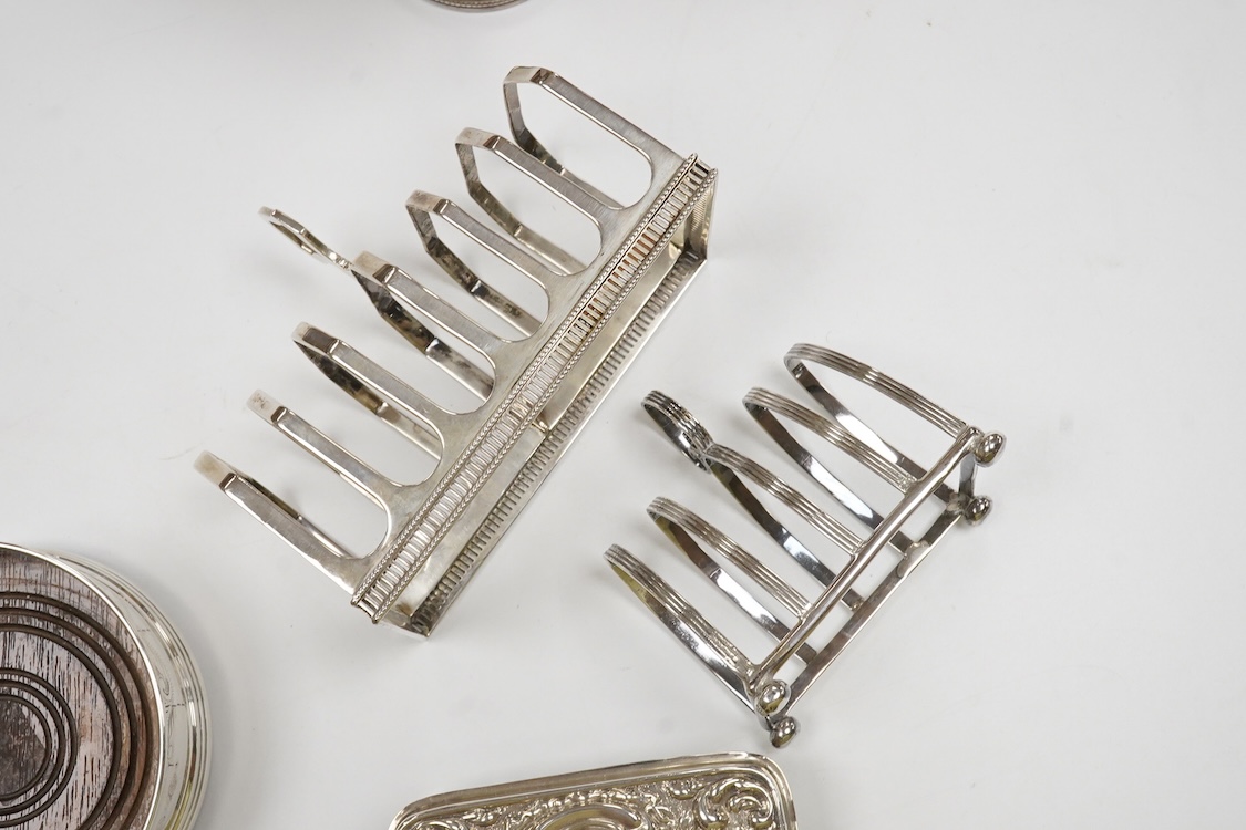 A George III engraved silver helmet shaped cream jug, Henry Chawner, London 1788(repair), height 15.3cm, together with two George V silver toast racks, a silver mounted glass toilet jar and a modern silver mounted bottle